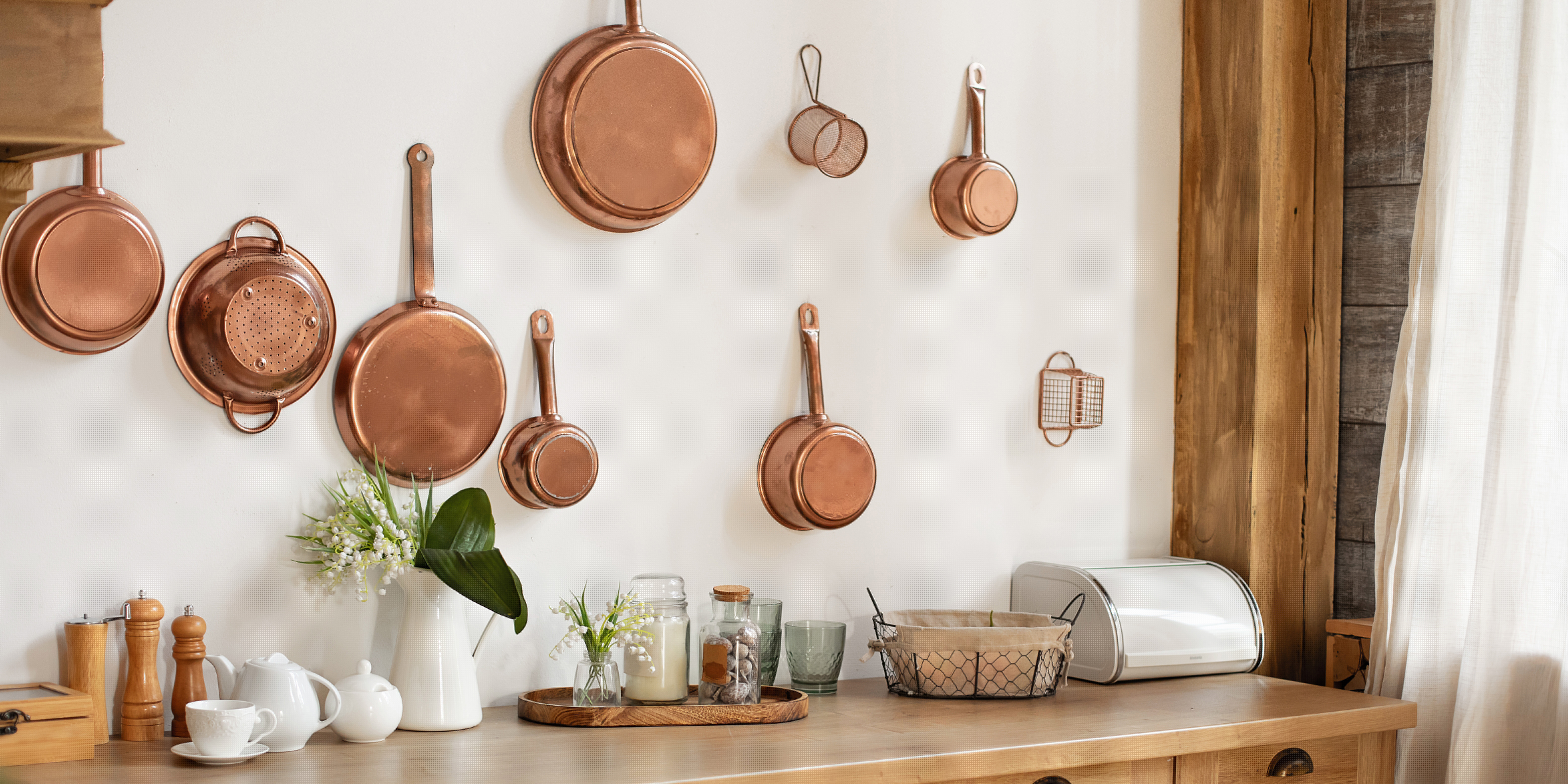 copper pans hanging from a pegboard in a small kitchen