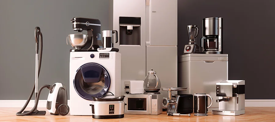 A stock photo displaying various major and small kitchen appliances, including a refrigerator, washing machine, vacuum and coffee maker.