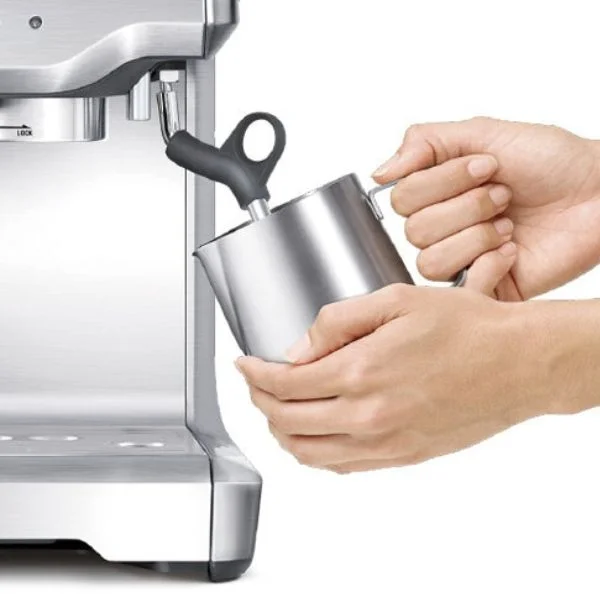 Person frothing milk on the Breville Barista Express.