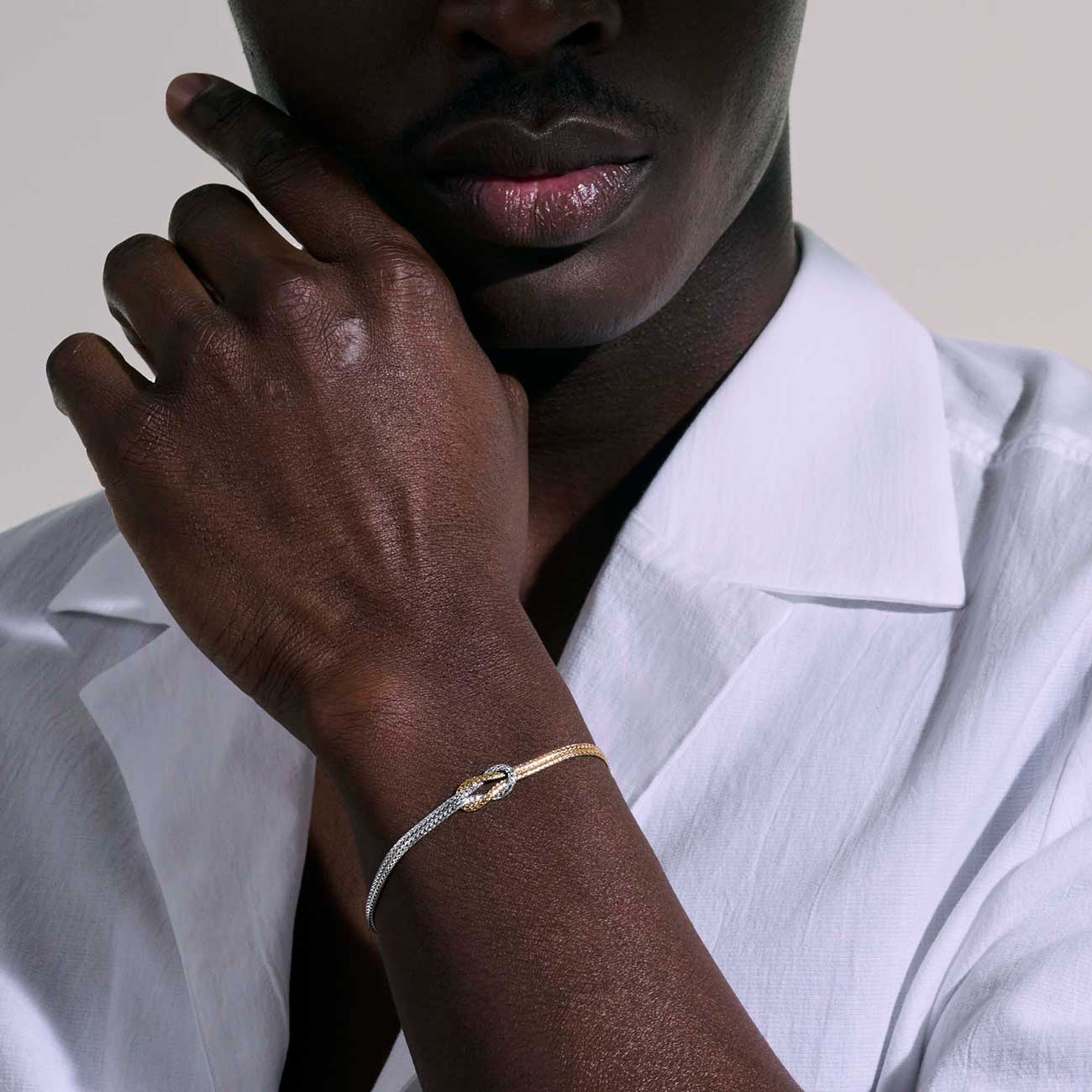 View of silver and gold knot chain bracelet on model