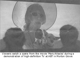 Viewers watch a scene from the movie 'Mars Attack' during a demonstration of high-definition TV at ABT in Morton Grove