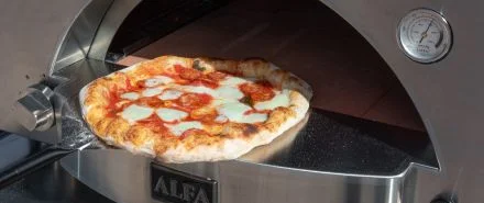 A pizza being moved out of an Alfa oven