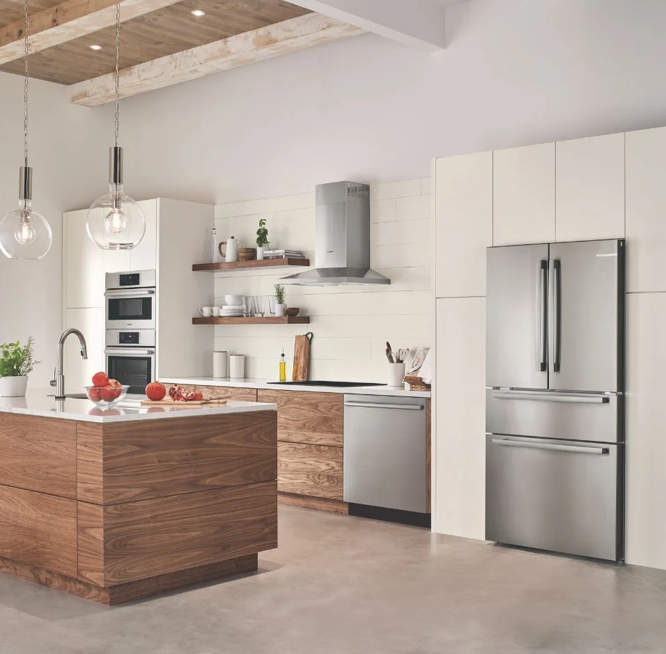 Modern kitchen with white cabinets, blue accents, and high-end Thermador Professional Collection appliances, including a range, rangehood, and wall oven