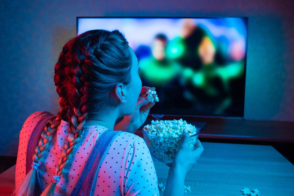 Child watching TV with popcorn