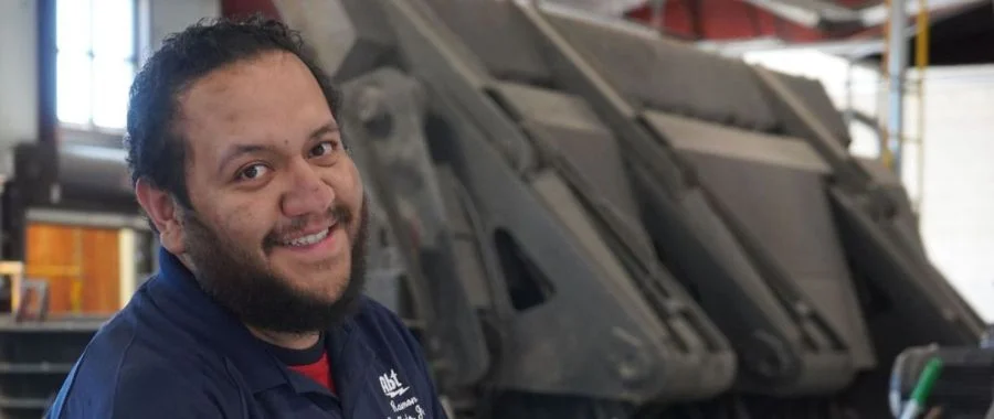 Ramon Mendez smiling at the camera in Abt's recycling center