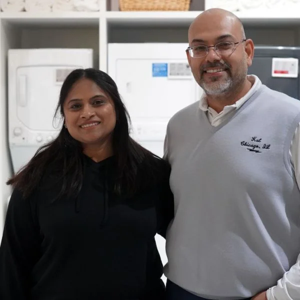 Kal and Vipra Madhiwala in front of Abt's display of stackable washer-dryers on the sales floor
