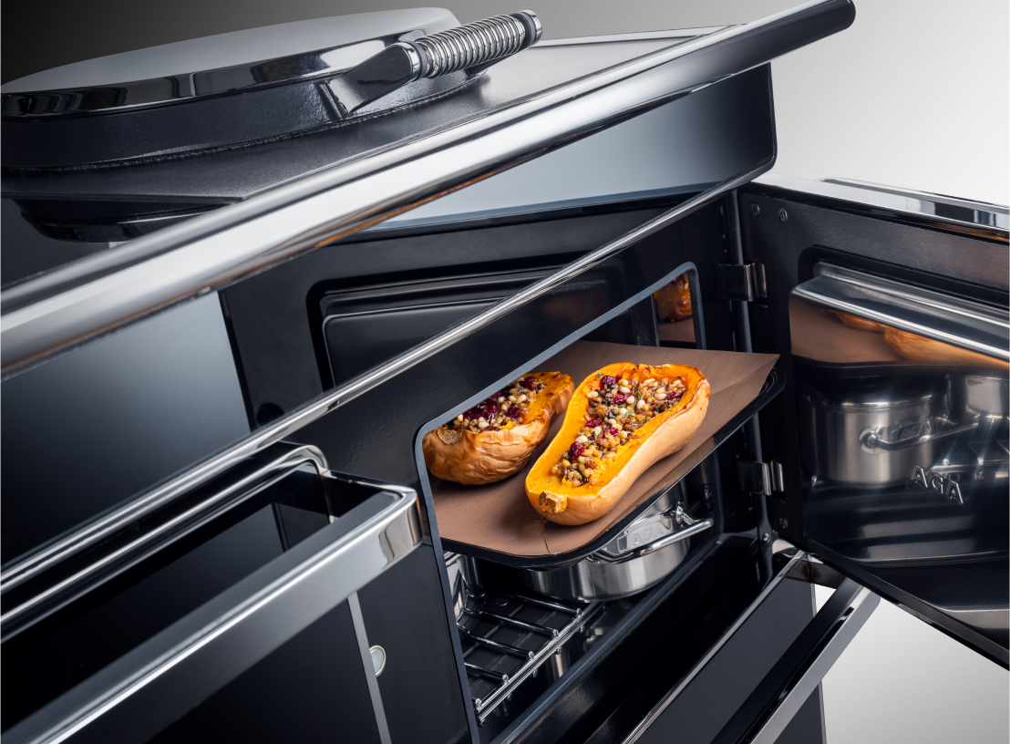 Transitional AGA kitchen with large hood vent and open shelves