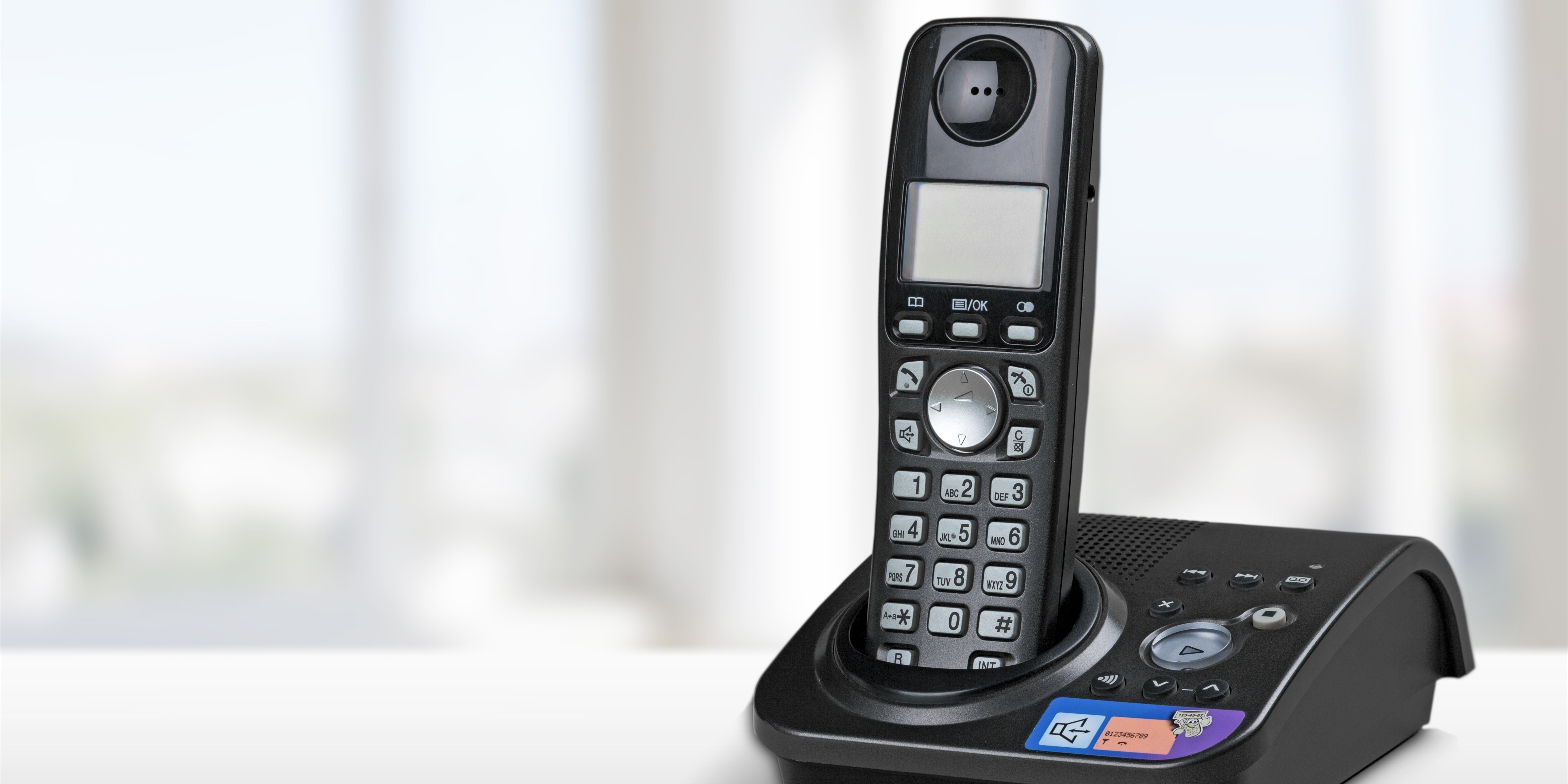 A black cordless phone on top of a table