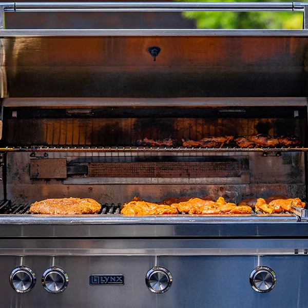 front view of Lynx stainless steel grill with chicken cooking
