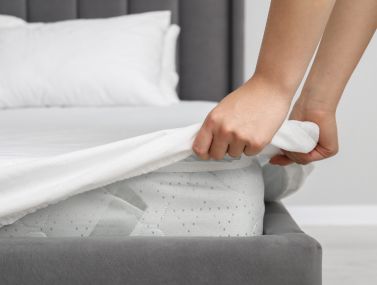 Lifestyle of a man putting on a mattress protector