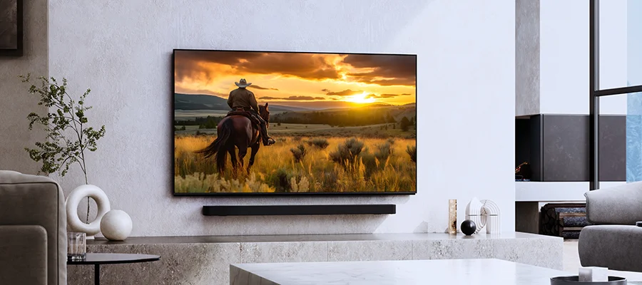 The Sony Bravia 9 mounted on the wall of a white room displaying an image of a cowboy riding a horse outside while the sun is setting