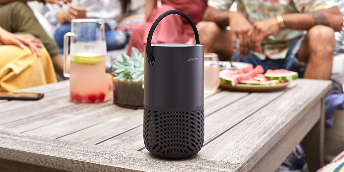 A black Bose wireless speaker sitting on a table outside