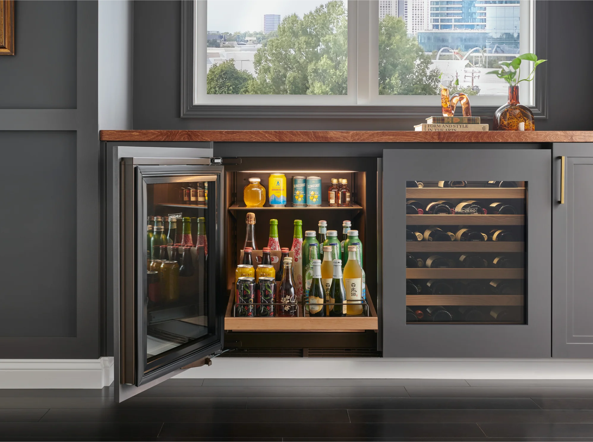 Sub-Zero built-in undercounter wine refrigerator with an open glass door showcasing beverages and wine inside