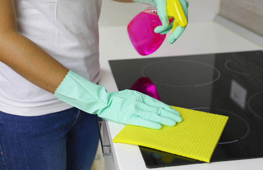 Spraying Cleaning Solution on Black Stovetop