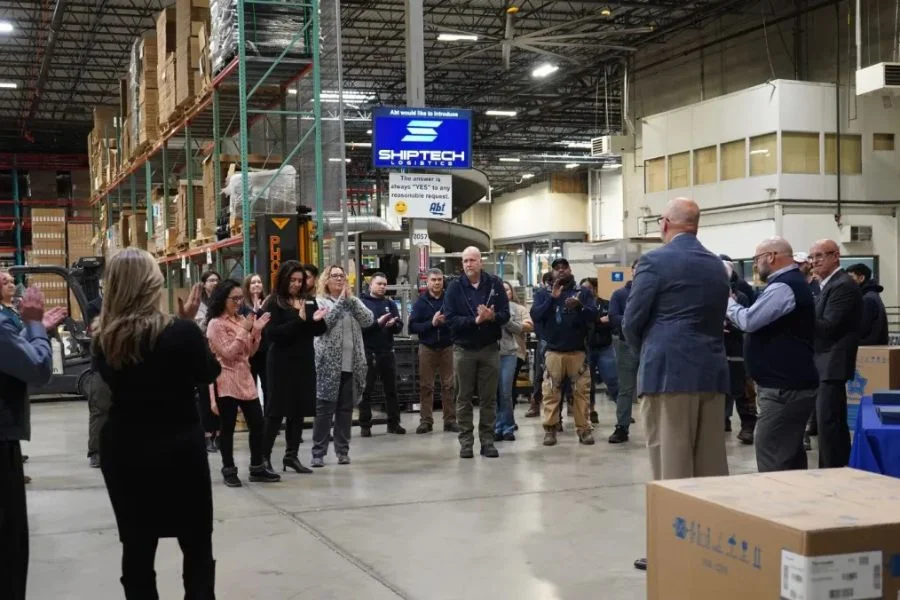 Abt's logistics team in the warehouse clapping for TCA's management team