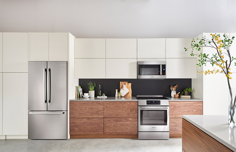 Kitchen with a Bosch 800 Series 36 Inch Counter-Depth Refrigerator Installed on the Left of Oak Cabinets
