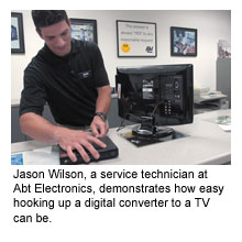 Jason Wilson, a service technician at Abt Electronics, demonstrates how easy hooking up a digital converter to a TV can be.
