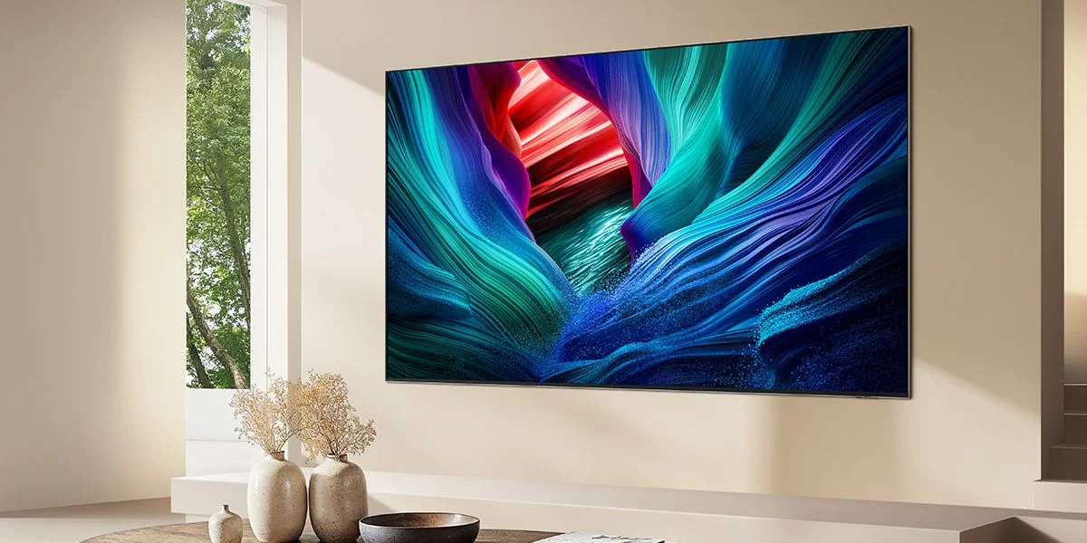 The bright colors of an RGB TV on a wall in a white living room. Sunlight streams in through a window.