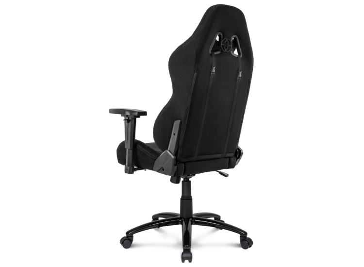 Front view of black gaming chair with adjustments visible, wide seat and footrest area.