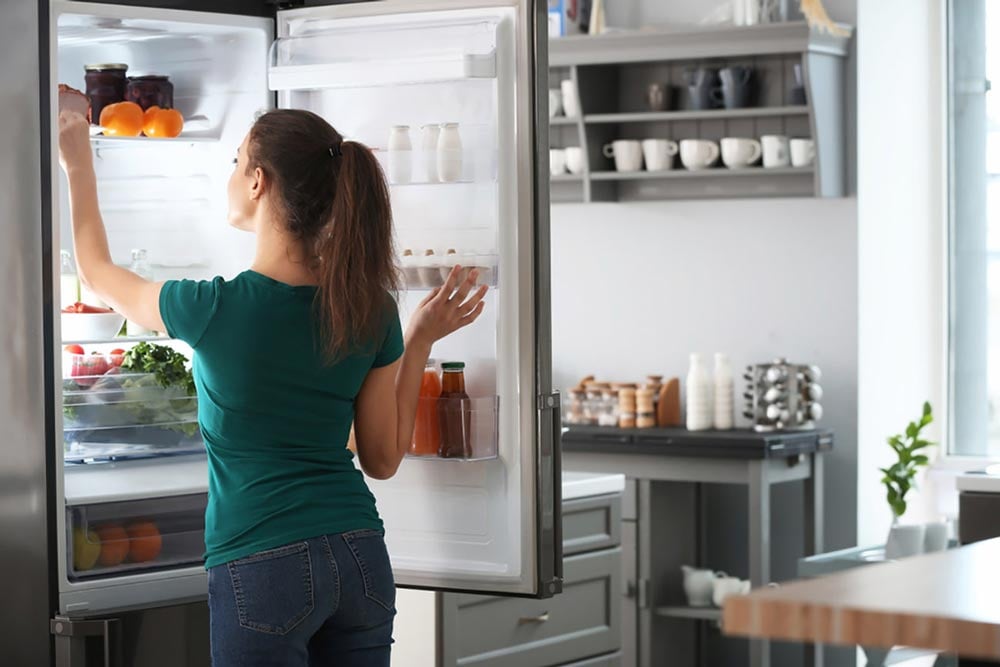 Person removing food before deforsting a refrigerator