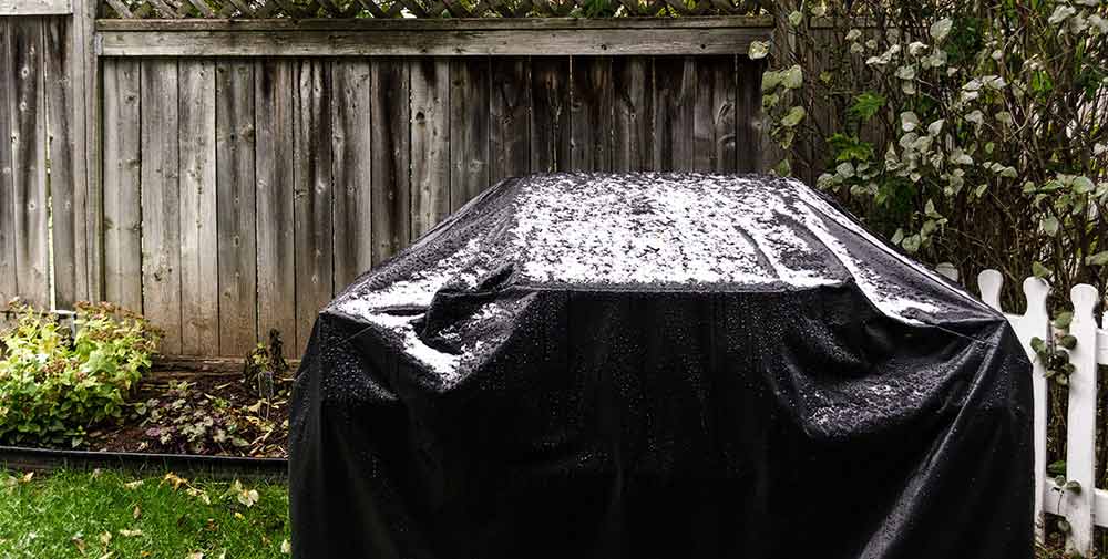 Grill under grill cover that is soaked in rain water