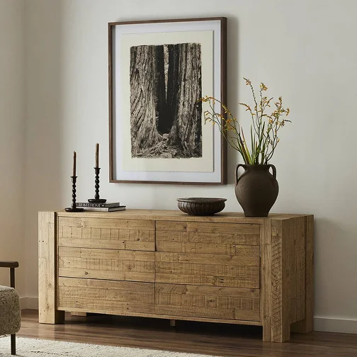 A wooden dresser with a decorative vase on top, showcasing a simple yet elegant home decor style.