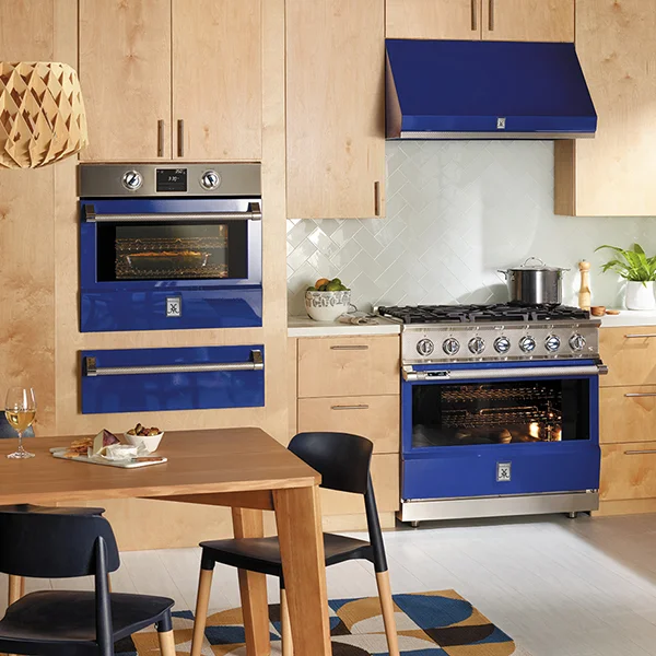 A kitchen with a dark blue wall oven, range and range hood