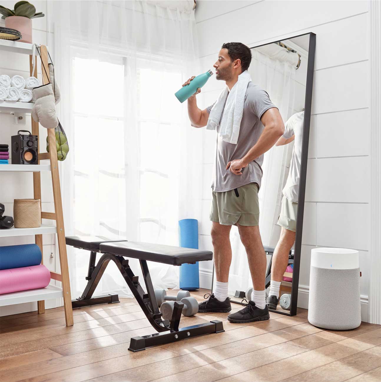 Blueair Air Purifier in a Home Gym with a Man Drinking Water
