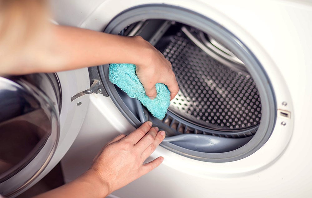 Person cleaning inside of front-load washer