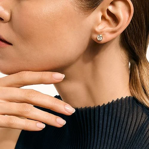 A warm colored tight shot on a persons ear with a John Hardy Diamind Stud Earring in