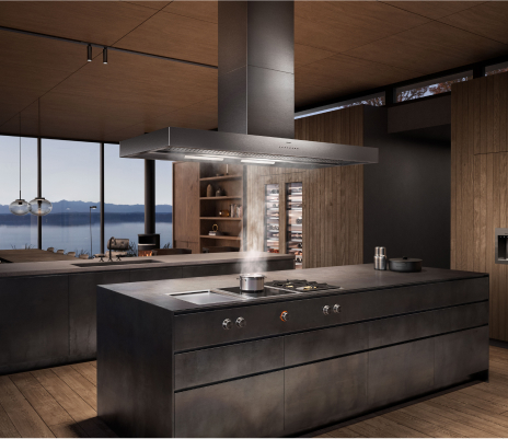 A sleek modern kitchen showcasing a large island, a stove, and a Gaggenau ventilation hood for optimal air circulation
