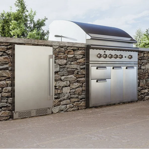 A small silver outdoor refrigerator installed next to a built-in grill