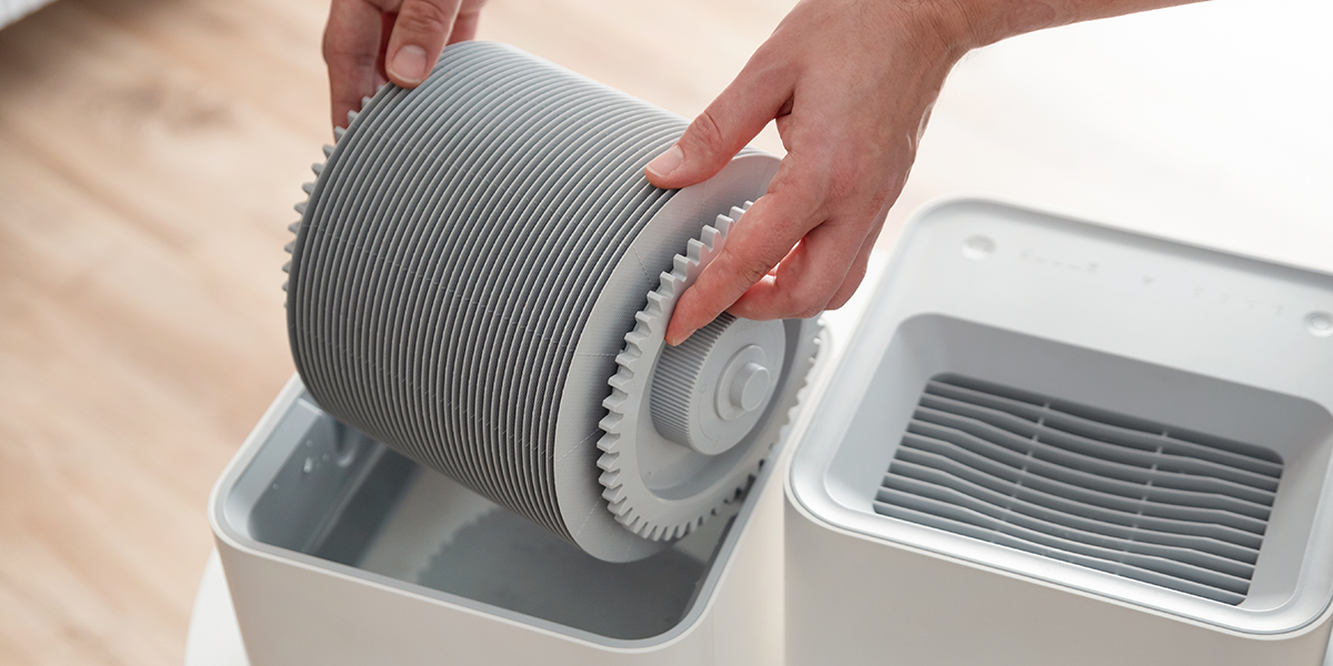 Hands pulling a humidifier filter out of the water tank