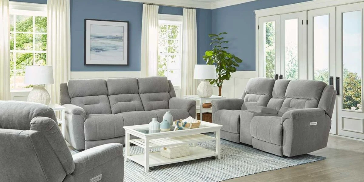 A living room with a full sofa, loveseat and chairs styled in a beachy, coast-inspired space