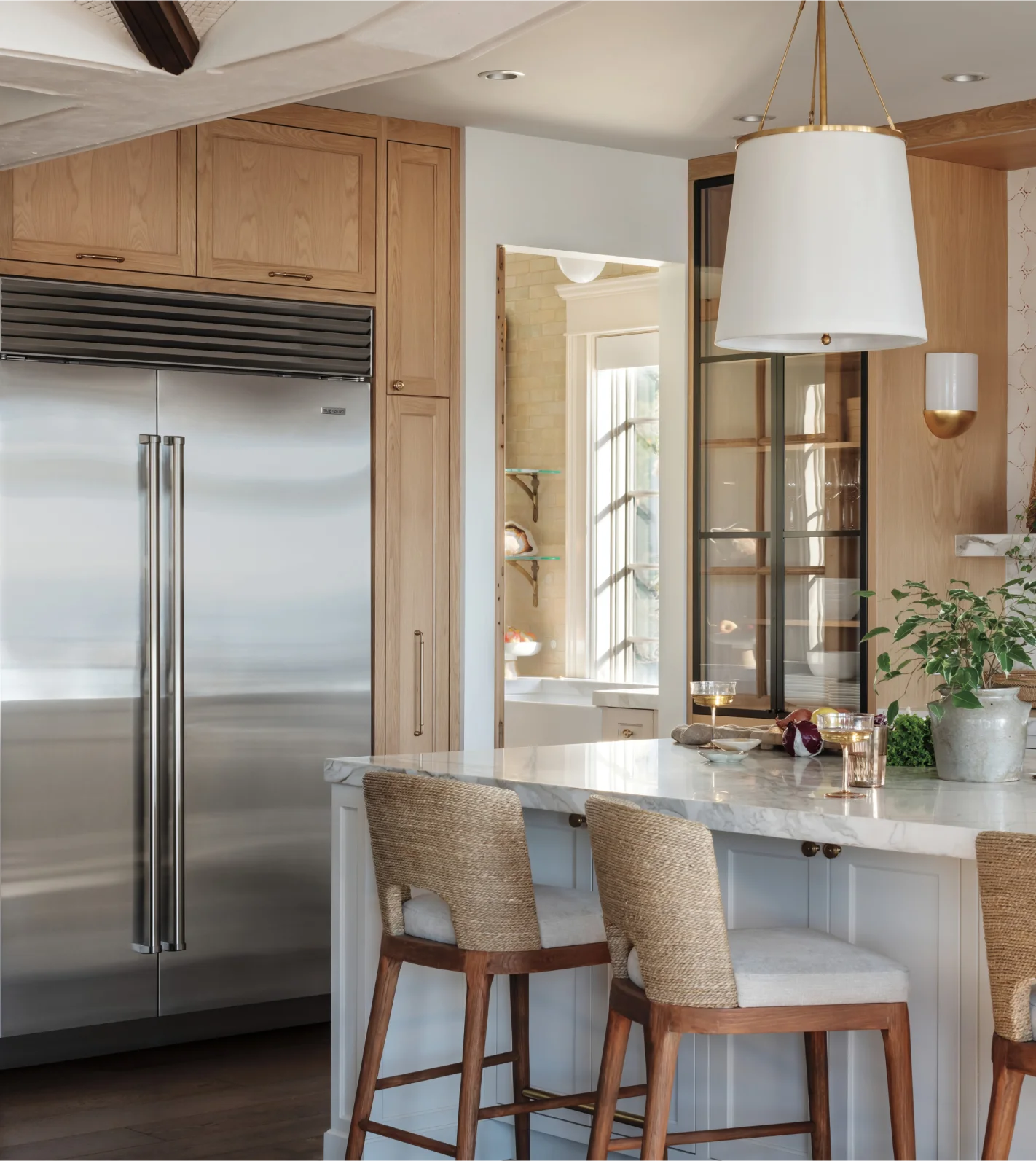 A modern kitchen featuring a spacious island and a sleek Sub Zero stainless steel refrigerator