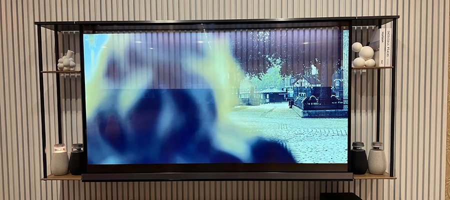 A transparent TV screen mounted on the wall, displaying a TV show