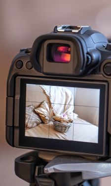 Digital camera sits on a tripod capturing a serene living room scene in the cameras display