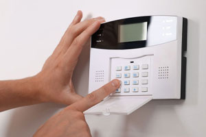 A user typing in an access code on a home security panel device