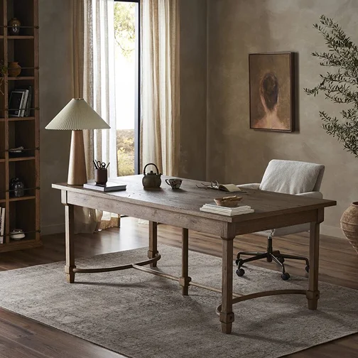 A desk accompanied by a lamp and a chair, situated in a room that offers a warm and inviting workspace.
