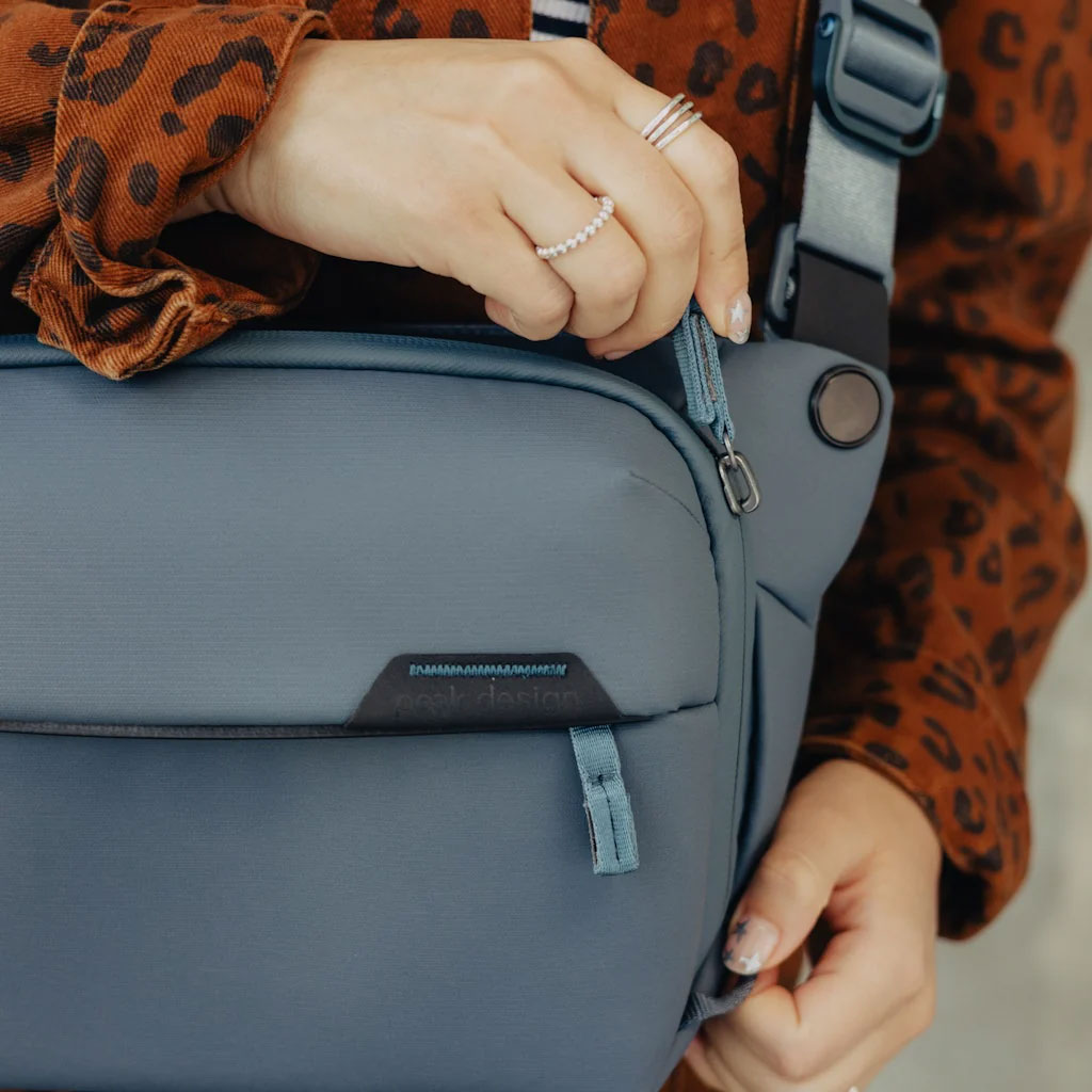 Woman Closing Peak Design Everyday Sling Over Shoulder