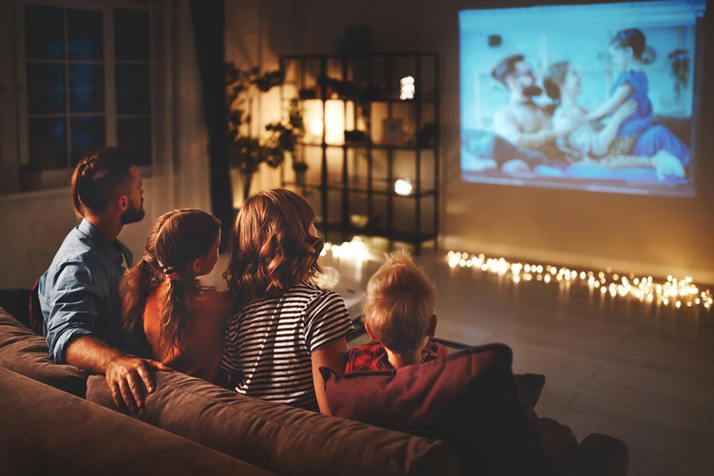 Family watching TV from a projector