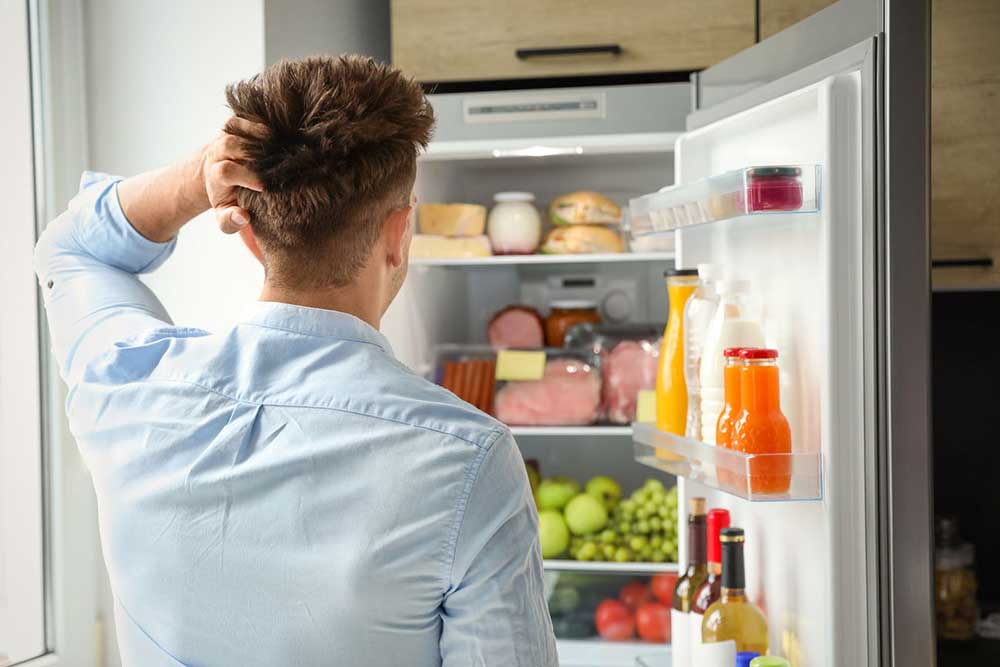 Technician looking at back of refrigerator