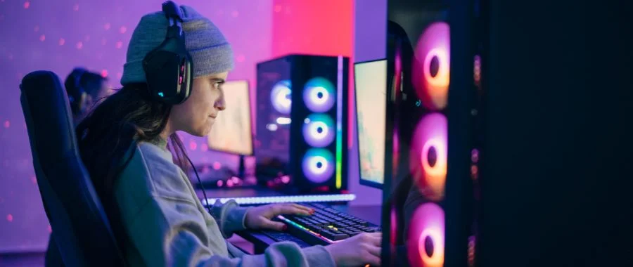 person with long hair wearing a beanie playing video games on a PC