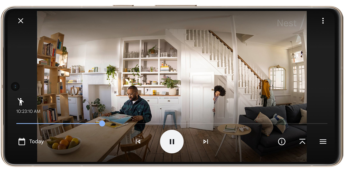 A smartphone screen displaying a Google Nest video feed of two people inside of their home.