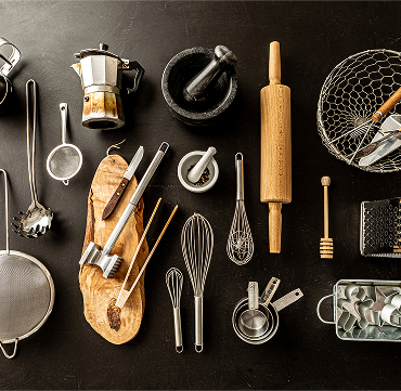 Overhead shot of various stainless steel and wooden kitchen tools