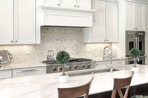 A kitchen island with white cabinetry
