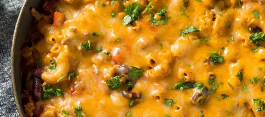 A large bowl of chili macaroini topped with cheese