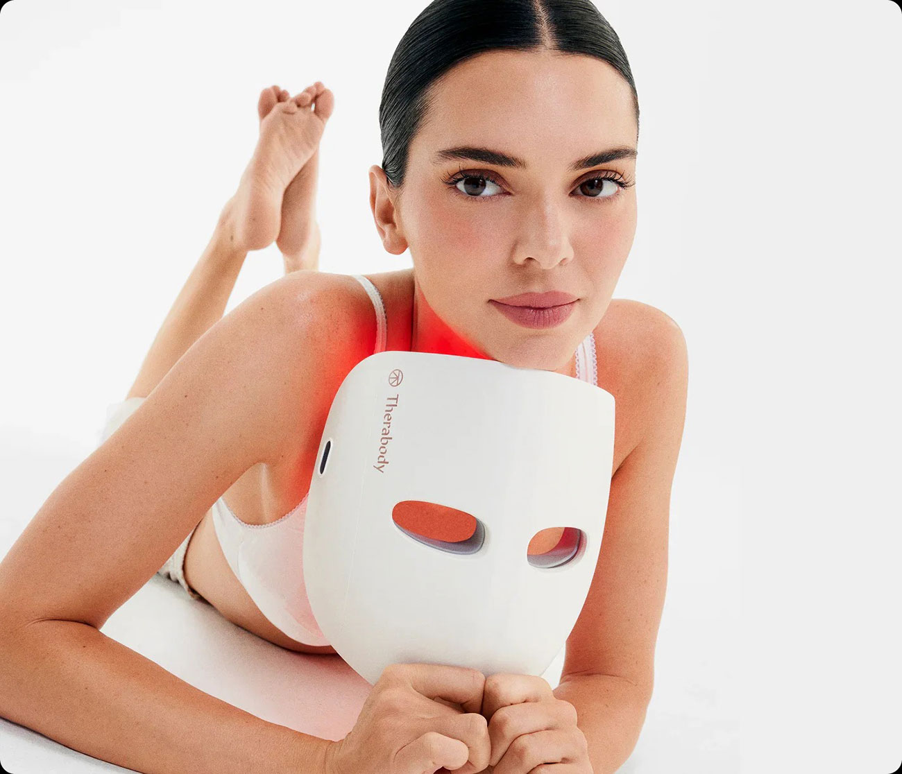 Woman Holding the Therabody Therapy Mask While Laying Down