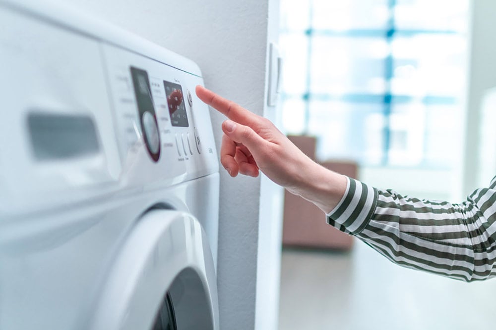 Person adjsuting settings on a dryer