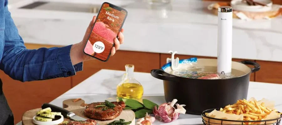 Woman cooking seafood in the Breville Joule Turbo Sous Vide cooker.